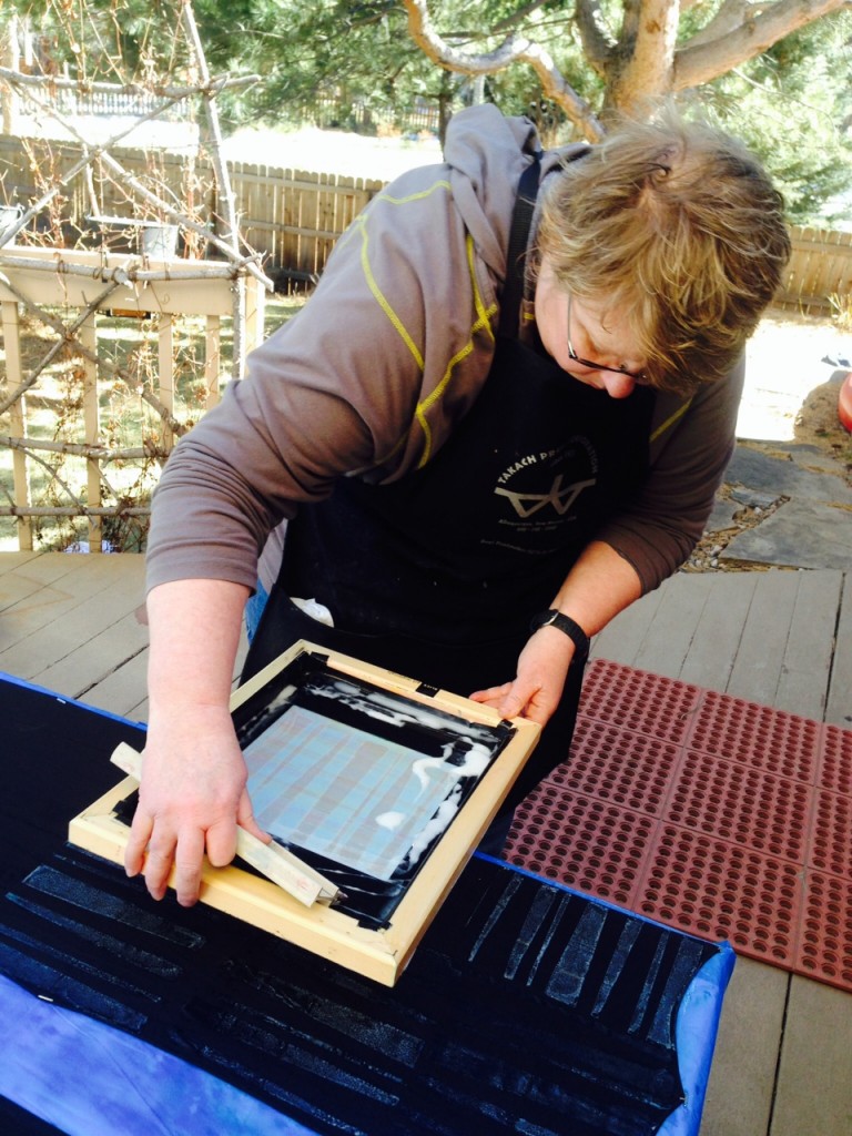 Artist at work:  screen-printing color remover on black silk scarves